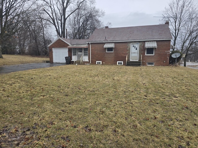 ranch-style home with aphalt driveway, entry steps, brick siding, and a front lawn