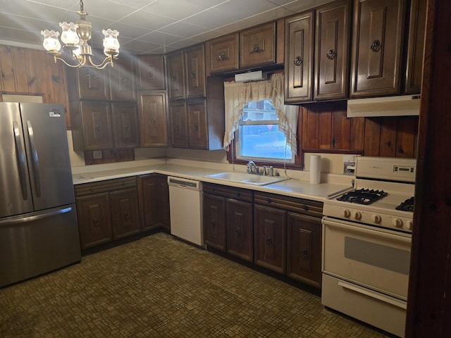 kitchen with light countertops, white appliances, a sink, and under cabinet range hood