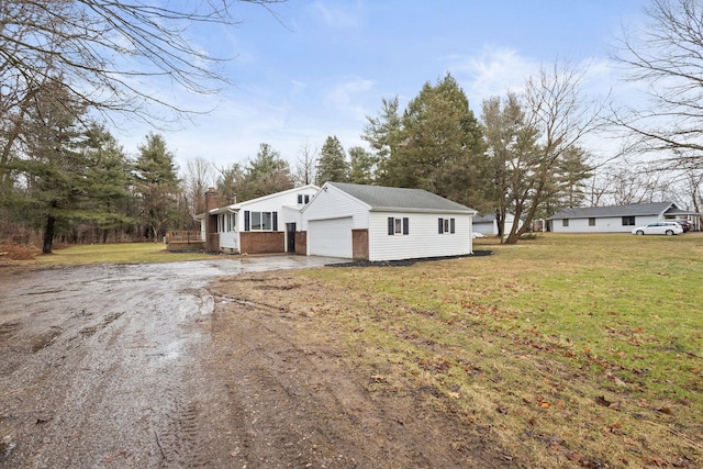 view of front facade featuring an attached garage, brick siding, driveway, a front lawn, and a chimney