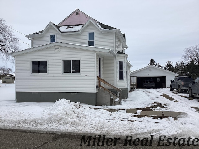 view of front of property featuring a garage, entry steps, crawl space, and an outdoor structure