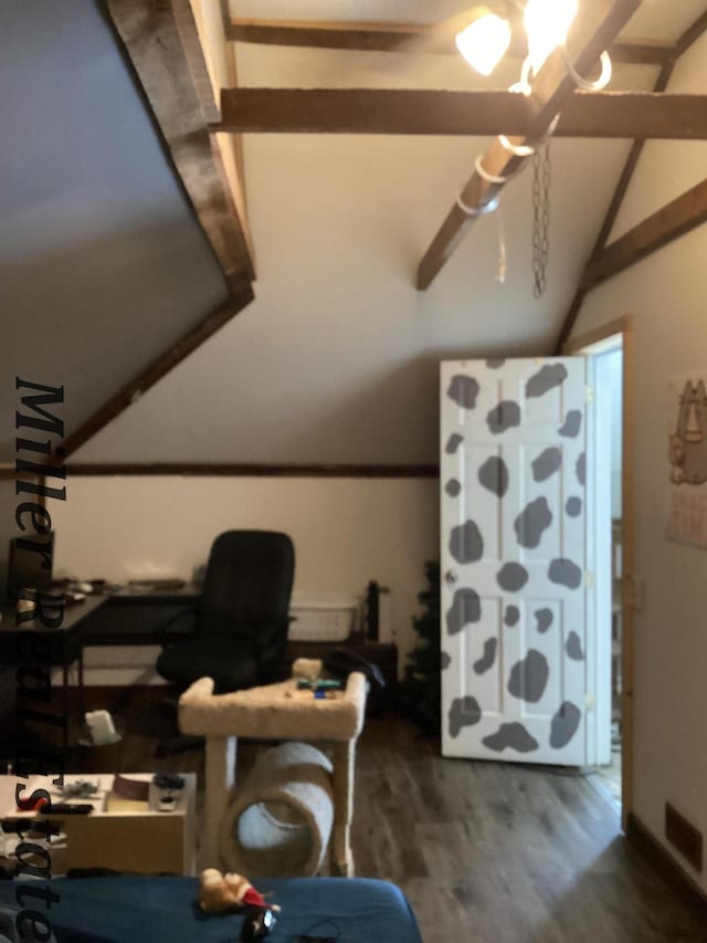 home office featuring vaulted ceiling, wood finished floors, and visible vents