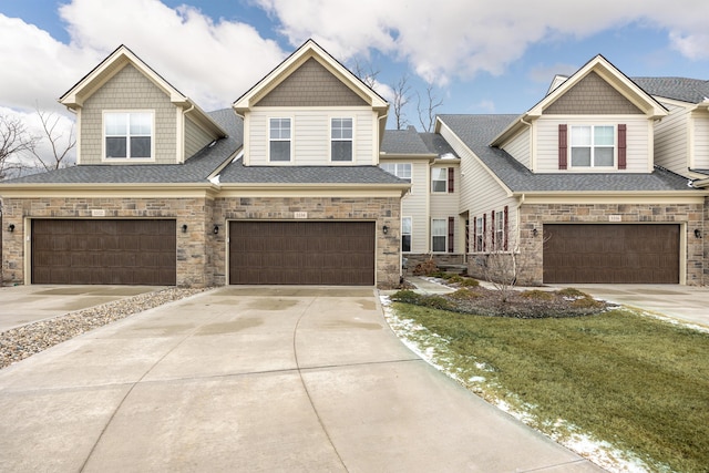 view of front of home featuring a garage, concrete driveway, and roof with shingles