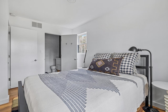 bedroom with visible vents and wood finished floors