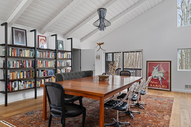 dining room with visible vents, wood-type flooring, beam ceiling, and baseboards