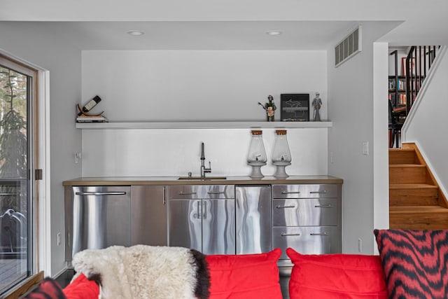 bar with stairs, stainless steel dishwasher, a sink, and visible vents