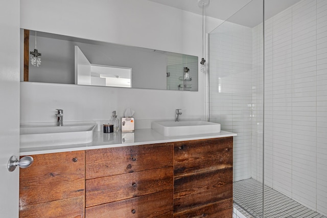 full bathroom with a sink, a shower stall, and double vanity