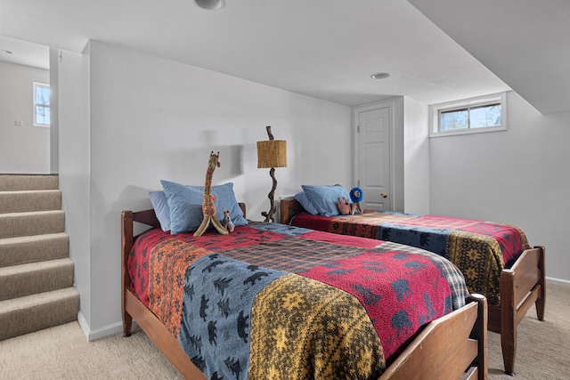 bedroom with light carpet, baseboards, and multiple windows