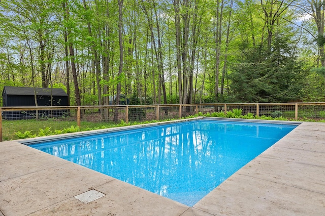 view of pool featuring a fenced in pool, an outbuilding, and fence