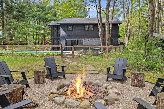 back of house featuring an outdoor fire pit and a fenced in pool