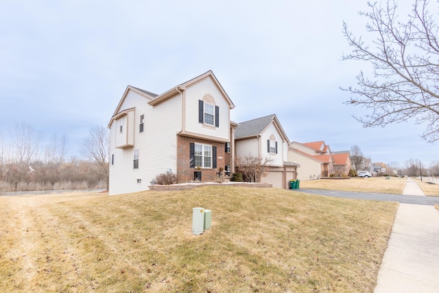 view of front of house with a garage, brick siding, and a front yard