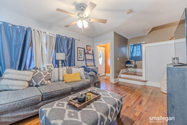 living room with baseboards, ceiling fan, and wood finished floors