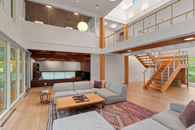 living area with stairway, a high ceiling, and wood finished floors