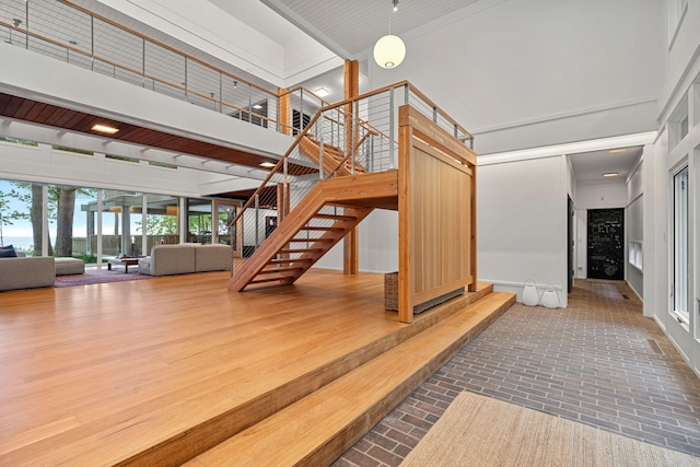 stairway featuring a high ceiling and wood finished floors