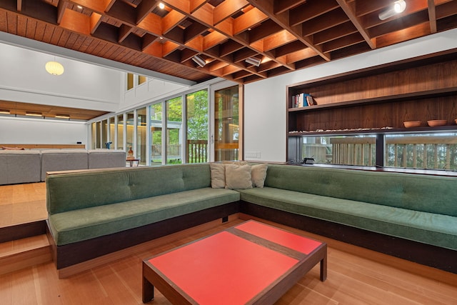 unfurnished living room with coffered ceiling, beamed ceiling, and wood finished floors