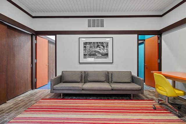 living area featuring brick floor, visible vents, and ornamental molding