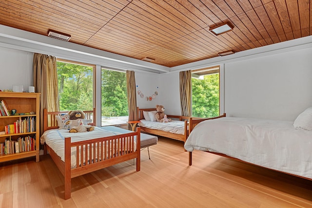 bedroom with wood ceiling and light wood-style flooring