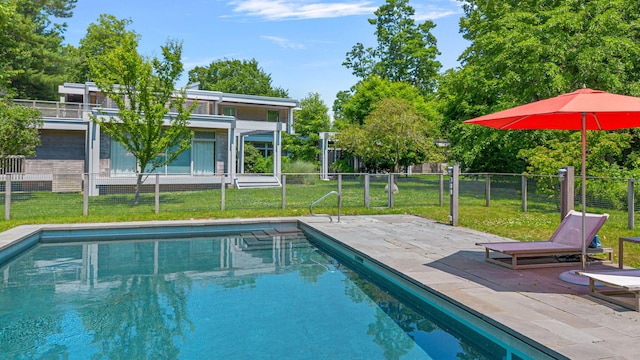 view of swimming pool featuring a yard, a patio area, fence, and a fenced in pool