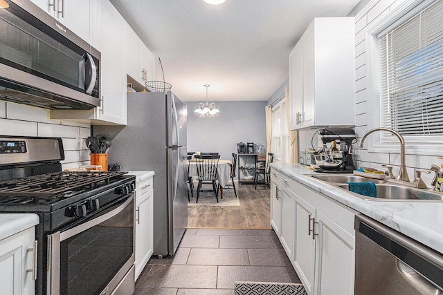 kitchen featuring stainless steel appliances, a sink, light countertops, and white cabinetry