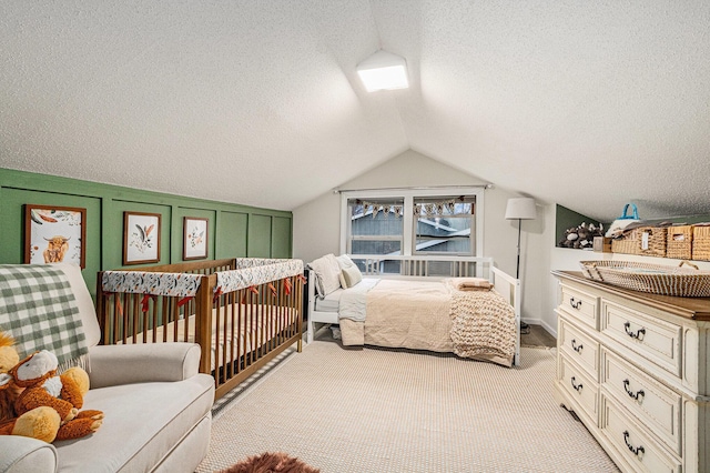 carpeted bedroom with vaulted ceiling and a textured ceiling