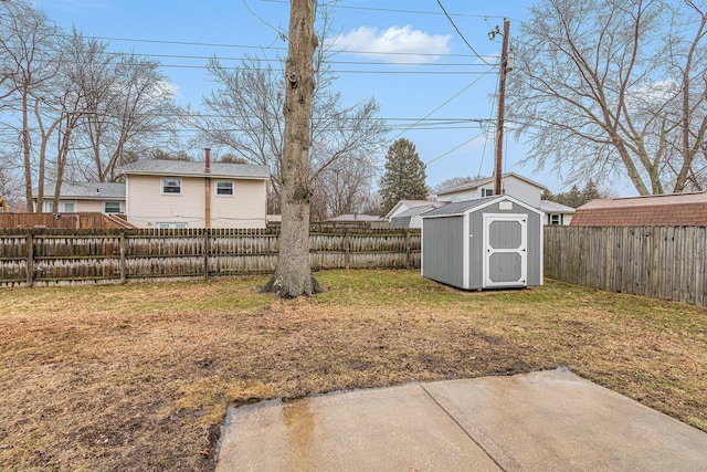 view of yard featuring a fenced backyard, an outdoor structure, and a storage shed