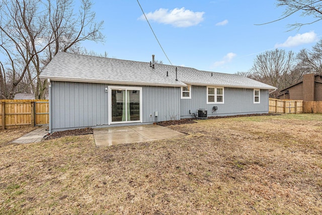 rear view of property with roof with shingles, a patio, a lawn, cooling unit, and a fenced backyard