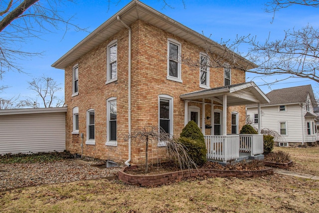 rear view of property featuring a porch and brick siding