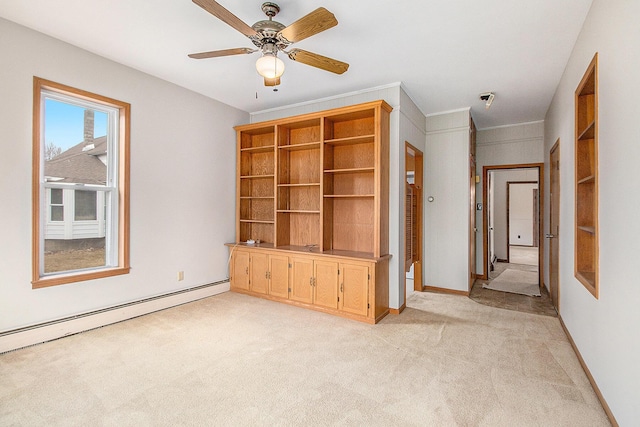 empty room featuring ceiling fan, a baseboard radiator, light colored carpet, baseboards, and crown molding