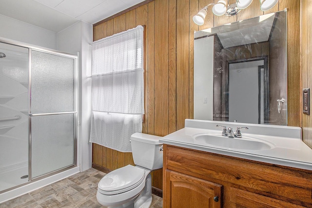 bathroom with toilet, wood walls, vanity, and a stall shower