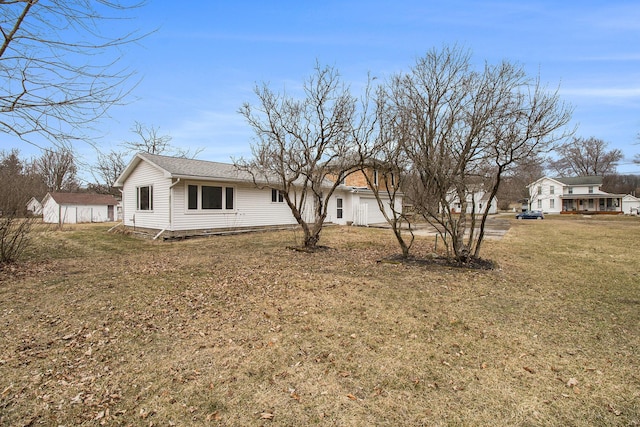 rear view of property featuring a lawn and an attached garage