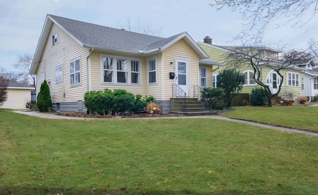 view of front of property featuring a front lawn, a chimney, and a shingled roof