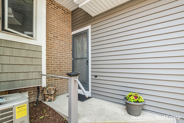 606 Edgewater Ct, Spring Lake, MI 49456 - property entrance with cooling unit and brick siding