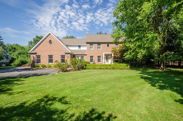 view of front facade featuring brick siding and a front lawn