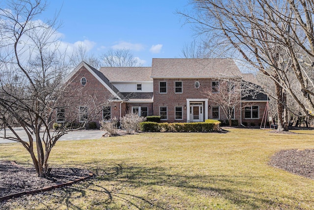 view of front of property featuring brick siding and a front yard