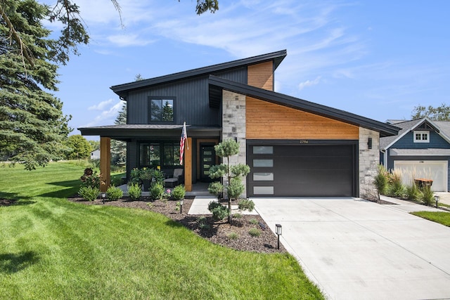 modern home featuring a front yard, driveway, and an attached garage