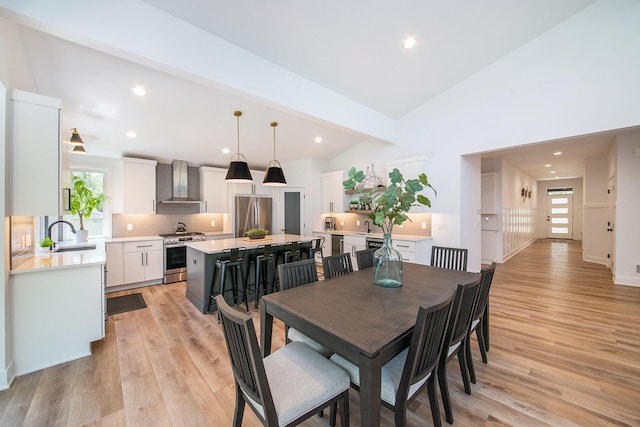 dining space with a healthy amount of sunlight, light wood finished floors, and beamed ceiling