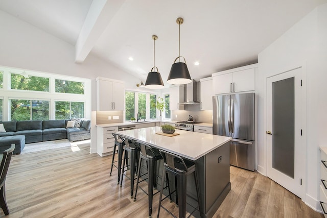 kitchen with decorative backsplash, appliances with stainless steel finishes, a kitchen breakfast bar, a sink, and beam ceiling