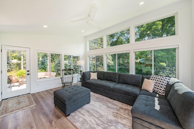 living room with recessed lighting, a high ceiling, a ceiling fan, wood finished floors, and baseboards