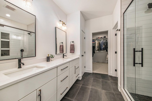 bathroom with a sink, visible vents, and a shower stall