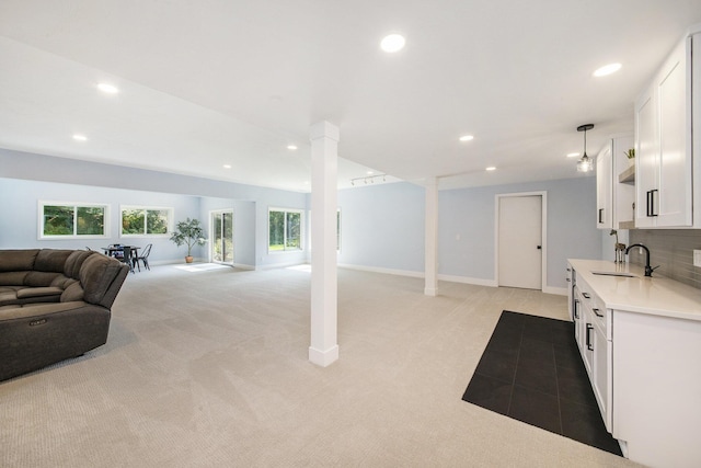 interior space with light carpet, ornate columns, baseboards, and recessed lighting