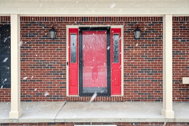 view of exterior entry with brick siding