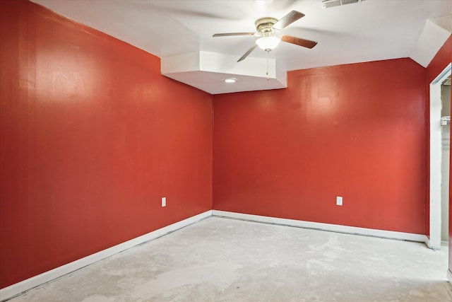 spare room featuring lofted ceiling, concrete floors, visible vents, a ceiling fan, and baseboards