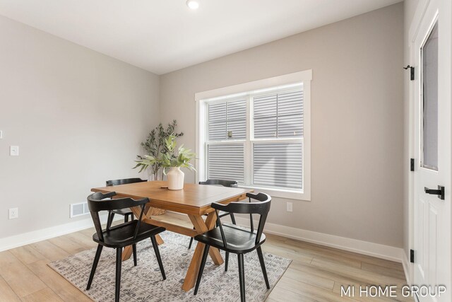 dining space with visible vents, baseboards, and light wood-style flooring