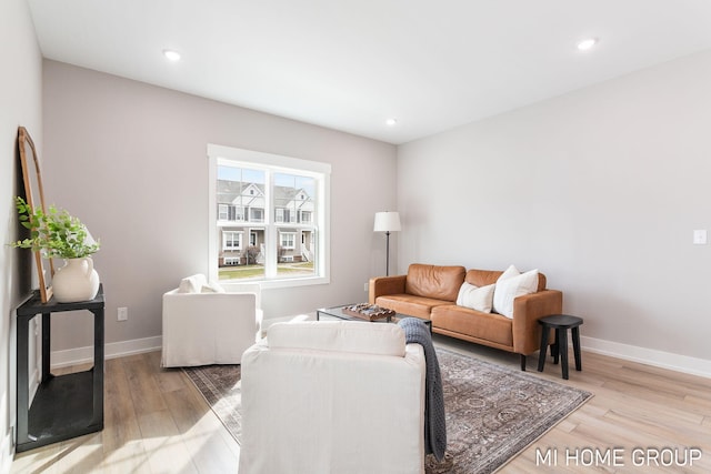 living room with recessed lighting, baseboards, and light wood finished floors