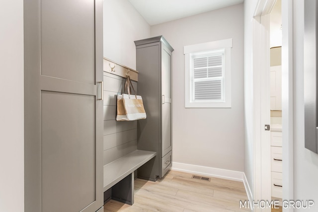 mudroom featuring visible vents, baseboards, and light wood finished floors