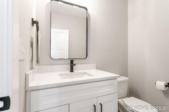 half bath featuring toilet and vanity