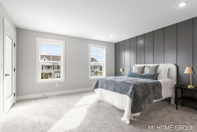 bedroom with baseboards and light colored carpet