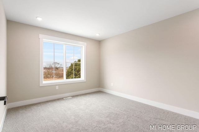 spare room featuring visible vents, baseboards, and carpet