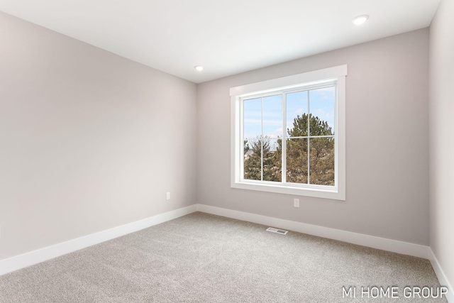 spare room with visible vents, recessed lighting, baseboards, and carpet