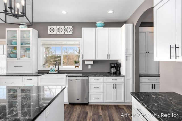 kitchen with dark wood finished floors, white cabinets, a sink, and stainless steel dishwasher