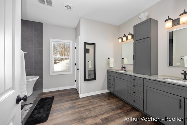 bathroom with visible vents, a sink, and wood finished floors